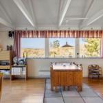 Raum mit Essbereich, Fenster zur Dünung und Holzmöbel.