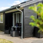 Holzhaus mit Terrasse, Sitzgruppe und Pflanzen im Garten.