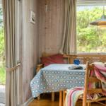 Essbereich mit Holztisch, Stühlen und Fensterblick auf Grün.