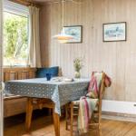 Essbereich mit Holzwand, Tisch, Stühle und Fenster mit Blick auf Grün.