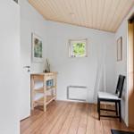 Eingangsbereich mit Holzboden, Kleiderständer und Tür zum Außenbereich.