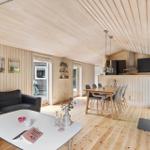 Wohn- und Essbereich mit Holzdecke, Sofa, Tisch und Kaminofen.