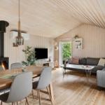 Wohn- und Essbereich mit Holzdecke, Sofa, Esstisch und Kamin.