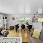 Wohn- und Essbereich mit Sofa, Tisch und Stühlen. Holzboden und weiße Wände.