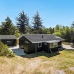 Moderne Holzhütte mit Terrasse und Grillplatz im Wald.