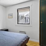 Schlafzimmer mit Bett, Fenster und grüner Tür.