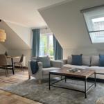 Wohn- und Essbereich mit Sofa, Tisch und Fenster
