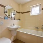 Badezimmer mit Badewanne, Waschbecken und Spiegel