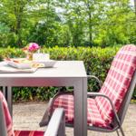 Außentisch mit Stühlen und Frühstück im Garten.