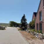 Pflasterweg neben rotem Backsteinhaus mit Steinmauer und Bäumen