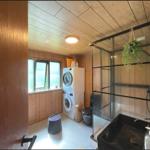 Badezimmer mit Dusche, Waschmaschine und Fenster mit Blick.