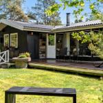 Holzhütte mit Terrasse, Garten und Blick in den Wald.