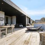 Deck with dining table, lounge chair, and garden furniture outdoors.