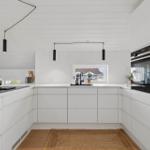 Modern kitchen with white cabinets and built-in oven.