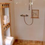 Dusche mit Duschbrause, Handtuchhalter und Bodenfliesen.