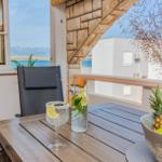 Terrasse mit Tisch, Stuhl und Obst. Blick auf Meer und Himmel.