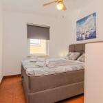 Schlafzimmer mit Bett, Fenster und Wandbild.