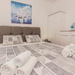 Schlafzimmer mit Bett, Kleiderschrank und Wandbild mit Segelbooten.