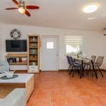 Wohn- und Essbereich mit Sofa, Tisch, Stühlen und Küchenzeile.