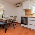 Küche mit Esstisch, Fenstern und Kühlschrank.