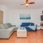 Wohnzimmer mit Sofa, Couchtisch und Fernseher an der Wand.