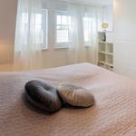 Schlafzimmer mit Bett, zwei Kissen, Fenster und Schrank.