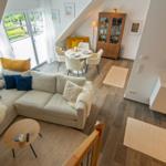 Wohn- und Essbereich mit Sofa, Tisch und Fenster zur Terrasse.