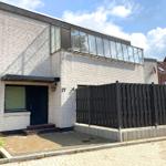 Moderne Villa mit weißen Ziegelwänden und großem Fensterband.