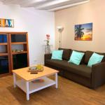 Ein Wohnzimmer mit braunem Sofa, türkisen Kissen und Holzboden.