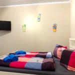 Zimmer mit zwei Betten, Wand-TV und Wanddekoration.