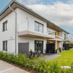 Moderne Villa mit Balkon, Terrasse und Garten. Sicht auf Wohnbereich und Außengrundstück.