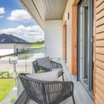 Terrasse mit zwei Sesseln und Blick auf Garten und Nachbarhaus.