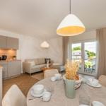 Wohnung mit Küche, Essbereich und Wohnzimmer mit Blick auf Garten.