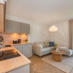 Küche mit Holzoberflächen und Wohnbereich mit Sofa und Couchtisch.