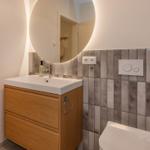 Badezimmer mit Waschbecken, Spiegel und Toilette