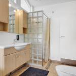Badezimmer mit Waschbecken, Dusche und Toilette.