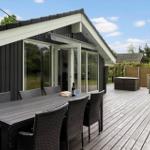 Terrasse mit Tisch und Stühlen, Anschluss an Wohnraum, Gartenbereich mit Sicht auf Bäume.