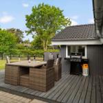 Terrasse mit Grill und Sitzgruppe im Freien.