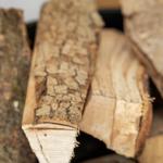 Ein Korb mit frischem Brennholz für den Kamin.