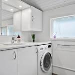 Badezimmer mit Waschmaschine und Spiegel an der Wand.