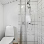 Bad mit Dusche und Toilette, weiße Fliesen und Fenster