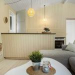 Wohnbereich mit Sofa, Küchenzeile und Fernseher an der Wand.