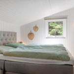 Schlafzimmer mit Bett, Fenster und Hängelampe.