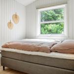 Schlafzimmer mit Bett, Fenster und Kleiderständer.