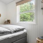 Schlafzimmer mit Bett, Fenster und Wanddekoration.