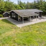 Hütte mit Terrasse, Grill und Liegen im Grünen.