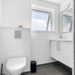 Badezimmer mit Toilette, Waschbecken und Fenster