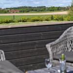 Terrasse mit Gartenmöbeln und Blick auf Felder und Bäume