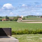 Terrasse mit Grill, Blick auf Felder und Dorf mit Kirche.