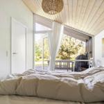 Schlafzimmer mit Bett, Fenster und Decke aus Holz.